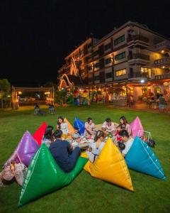 a group of people sitting on the grass with kites at Phanomrungpuri Hotel Buriram in Nang Rong