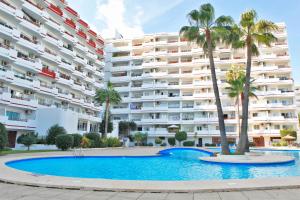 a swimming pool in front of a large apartment building at Apartamento Can Poma in Alcudia