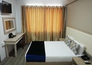 Un pat sau paturi într-o cameră la Regal Inn North Beach