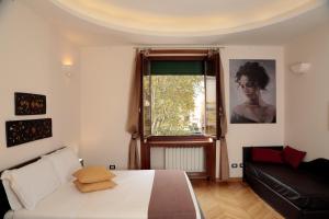 a bedroom with a bed and a couch and a window at Residenza Delle Arti in Rome