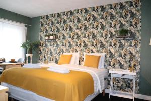 ein Schlafzimmer mit einem gelben Bett und einer Tapete in der Unterkunft Bed & Breakfast Hotel Zandvoort in Zandvoort
