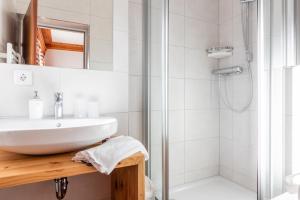 a bathroom with a sink and a shower at Hotel Kollerhof in Aich