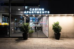 un front de magasin avec deux plantes en pot devant lui dans l'établissement Cabinn Apartments, à Copenhague