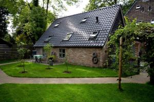 a house with two trees in front of it at Bed & Breakfast De Corylus in Oosterhesselen