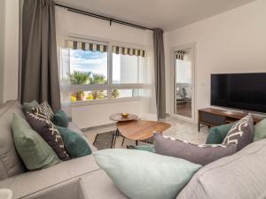 a living room with a couch and a large window at VACATION MARBELLA I Beachfront Quiet Apt with Private Beach Access in Marbella
