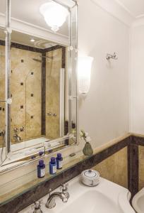 a bathroom with a sink, mirror, and bathtub at Villa Sant'Andrea, A Belmond Hotel, Taormina Mare in Taormina