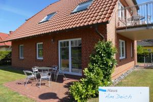 a house with a patio with a table and chairs at Haus am Deich Feriendomizil mit Terrasse in Baabe