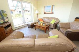 a living room with a couch and a table at Haus am Deich Feriendomizil mit Terrasse in Baabe