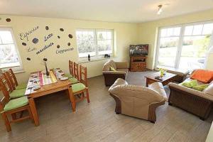 a living room with a couch and a table and chairs at Haus am Deich Feriendomizil mit Terrasse in Baabe