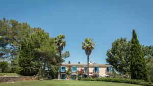 - une vue sur l'extérieur d'une maison avec des palmiers dans l'établissement Finca Son Miranda - LA Organic, à Sencelles