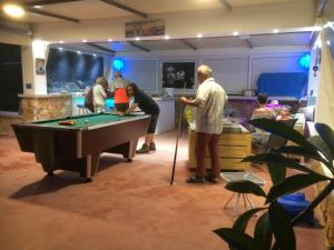 eine Gruppe von Menschen, die um einen Billardtisch stehen in der Unterkunft Poseidon Suites Hotel in Stavros