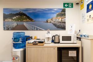 a room with a counter with a microwave and a balcony at Atotxa Rooms in San Sebastián