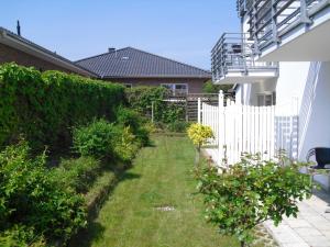 a garden with a white fence and some bushes at Ferienwohnung im Haus Katharina in Lauterbach