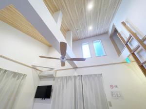 a ceiling fan in a room with curtains at nestay villa tokyo takanawa in Tokyo