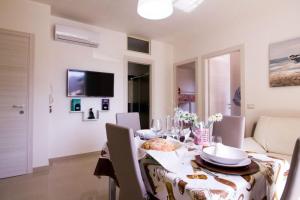 comedor con mesa, sillas y TV en Residence MareBlu, en Pozzallo