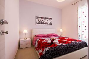 Residence MareBlu في بوزالو: غرفة نوم مع سرير مع وسائد وردية