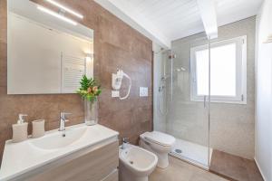 łazienka z umywalką, toaletą i prysznicem w obiekcie Prima dell'Elba Family Apartments w mieście Piombino +37 zdjęć
