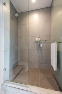 a shower with a glass door in a bathroom at Black Marble - Menlyn Residence Apartments in Pretoria
