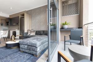 a living room with a couch and a table at Black Marble - Menlyn Residence Apartments in Pretoria