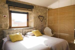 a bedroom with a large white bed with yellow pillows at Cal Ouaire House in Viladeséns