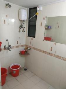 een badkamer met een wastafel, een spiegel en emmers bij Rutugandh Homestay Wai, Near Panchgani in Wai