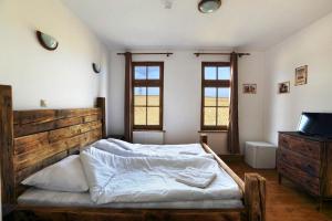 a bedroom with a bed and a tv and windows at Tordas Western House in Tordas