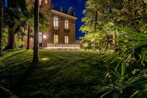 a lawn in front of a building at night at Villa Liberty in Como