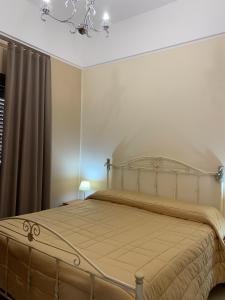 1 dormitorio con 1 cama con lámpara de araña en B&B Piazza del Popolo, en San Pietro Vernotico