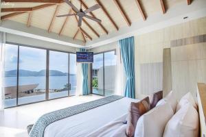 芭东海滩Kalima Resort and Spa的一间带大床和大窗户的卧室