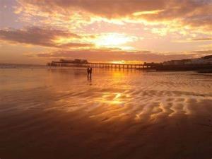 een persoon die bij zonsondergang op het strand staat bij NORTHRISE RETREAT in Hastings