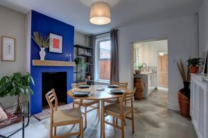uma sala de jantar com mesa e cadeiras e uma parede azul em Ideal for contractors discounted longer stays Designer city centre home with free parking em Norwich