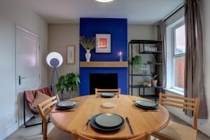 uma sala de jantar com uma mesa e uma parede azul em Ideal for contractors discounted longer stays Designer city centre home with free parking em Norwich