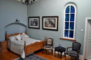 sypialnia z łóżkiem, 2 krzesłami i oknem w obiekcie Highfield House Guesthouse w mieście Trim
