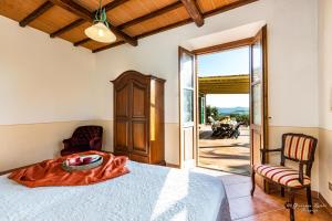 Un dormitorio con una cama y una puerta a un patio. en Bio Fattoria Il Poggiarello, en Volterra 149 fotos más