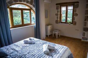 a bedroom with a bed with towels on it at To Spiti mas in Sougia