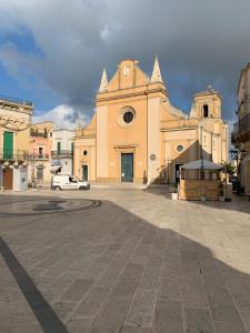 a church with a white car parked in front of it at Piazza del Popolo in San Pietro Vernotico