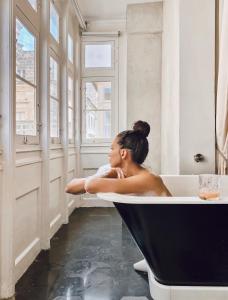 a woman sitting in a bath tub in a bathroom at Casa Ellul - Small Luxury Hotels of the World in Valletta
