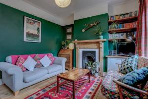 a living room with a couch and a fireplace at Perfect for contractors Arty and Quirky cozy house with free parking in Norwich