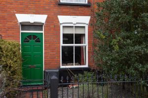 a green door and a window in a brick building at Perfect for contractors Arty and Quirky cozy house with free parking in Norwich