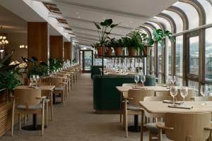 a restaurant with tables and chairs and windows at Original Sokos Hotel Vaakuna Helsinki in Helsinki