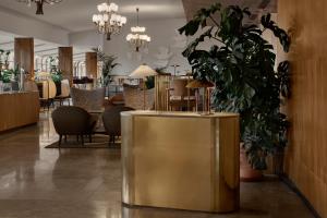 a lobby with a large gold table and chairs at Original Sokos Hotel Vaakuna Helsinki in Helsinki