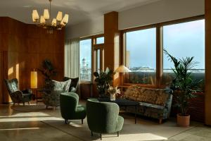 
a living room filled with furniture and a large window at Original Sokos Hotel Vaakuna Helsinki in Helsinki
