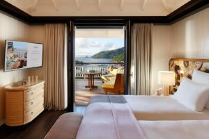Cette chambre d'hôtel comprend un lit et un balcon. dans l'établissement Hôtel Barrière Le Carl Gustaf St Barth, à Gustavia