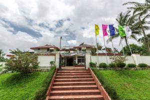 a building with three flags in front of it at KSTDC Hotel Mayura TalaKaveri, Bhagamandala in Madikeri