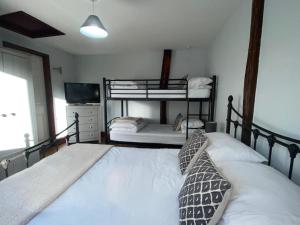 a bedroom with two bunk beds and a television at Low Farm Cottages in Woodbridge