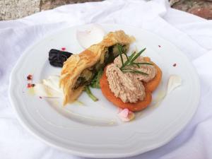 a white plate with food on a table at Agriturismo Fiamberta in Certosa di Pavia