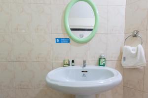 a bathroom with a white sink and a mirror at KSTDC Hotel Mayura TalaKaveri, Bhagamandala in Madikeri