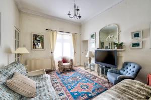 a living room with a couch and a tv at GuestReady - Classic Charm near Holyrood Park in Edinburgh