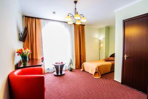 Habitación de hotel con cama y silla roja en Terminal-A Hotel, en Leópolis