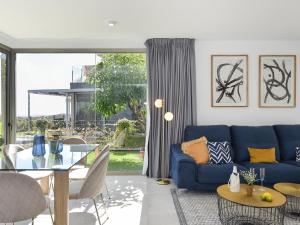 ein Wohnzimmer mit einem blauen Sofa und einem Glastisch in der Unterkunft Los Dragos Salobre Golf Villas 3 by VillaGranCanaria in Maspalomas